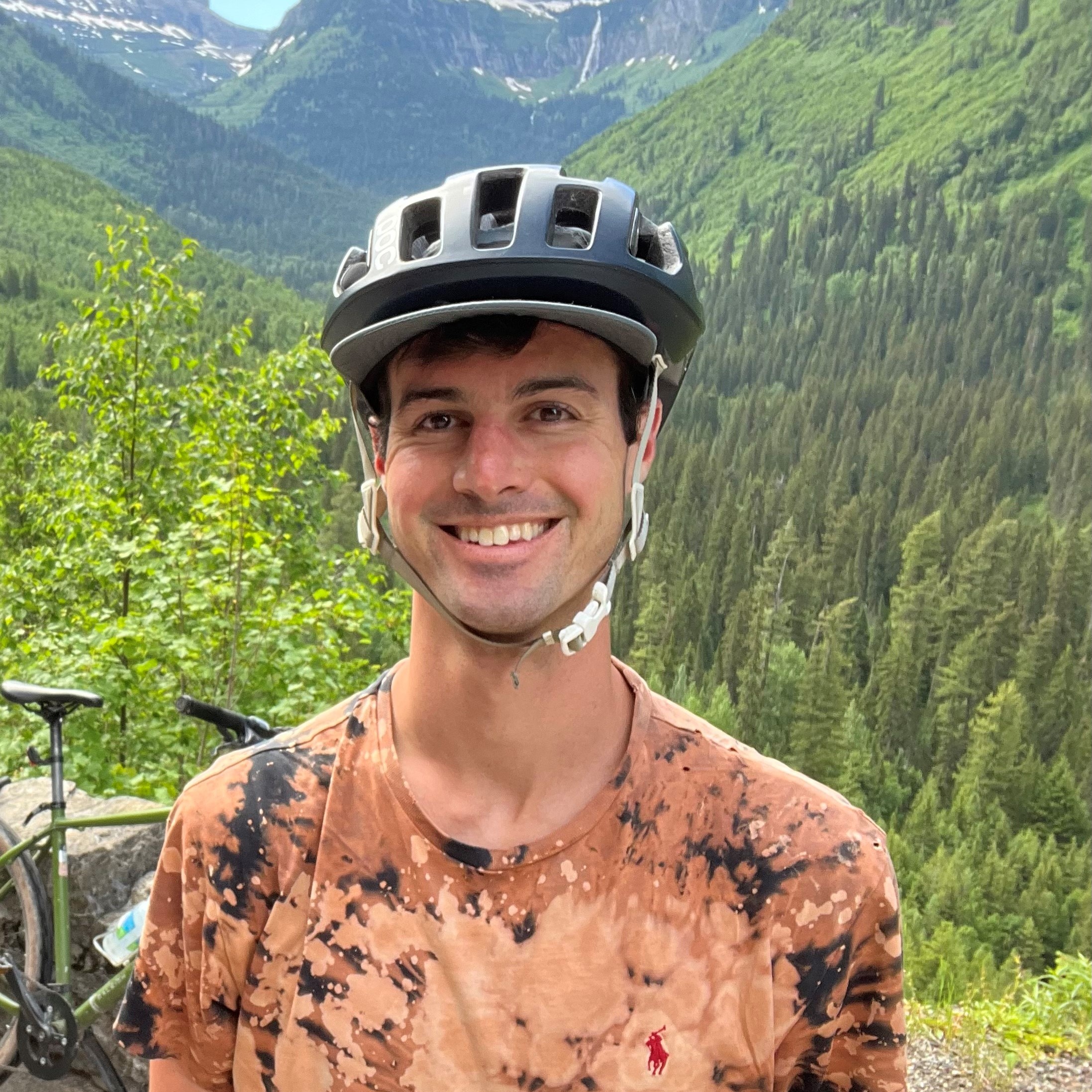 Man in bicycle helmet in forest mountain landscape