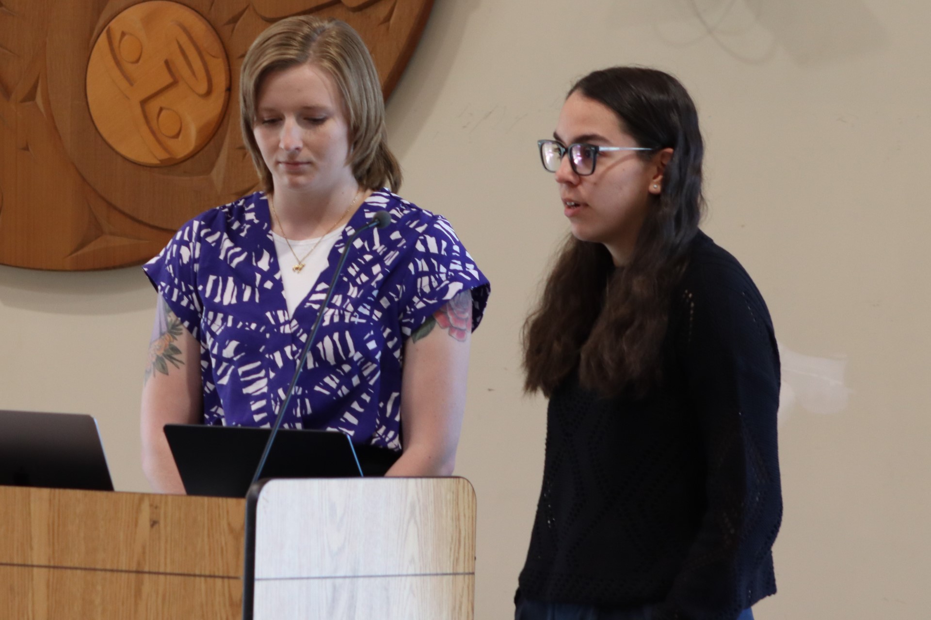 Two young woman at a lectern