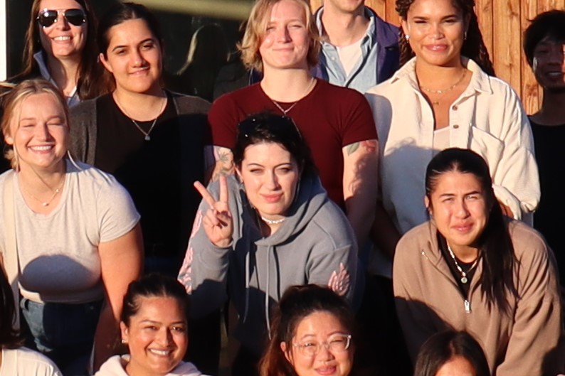 Students posing in crowd, centre one giving peace sign