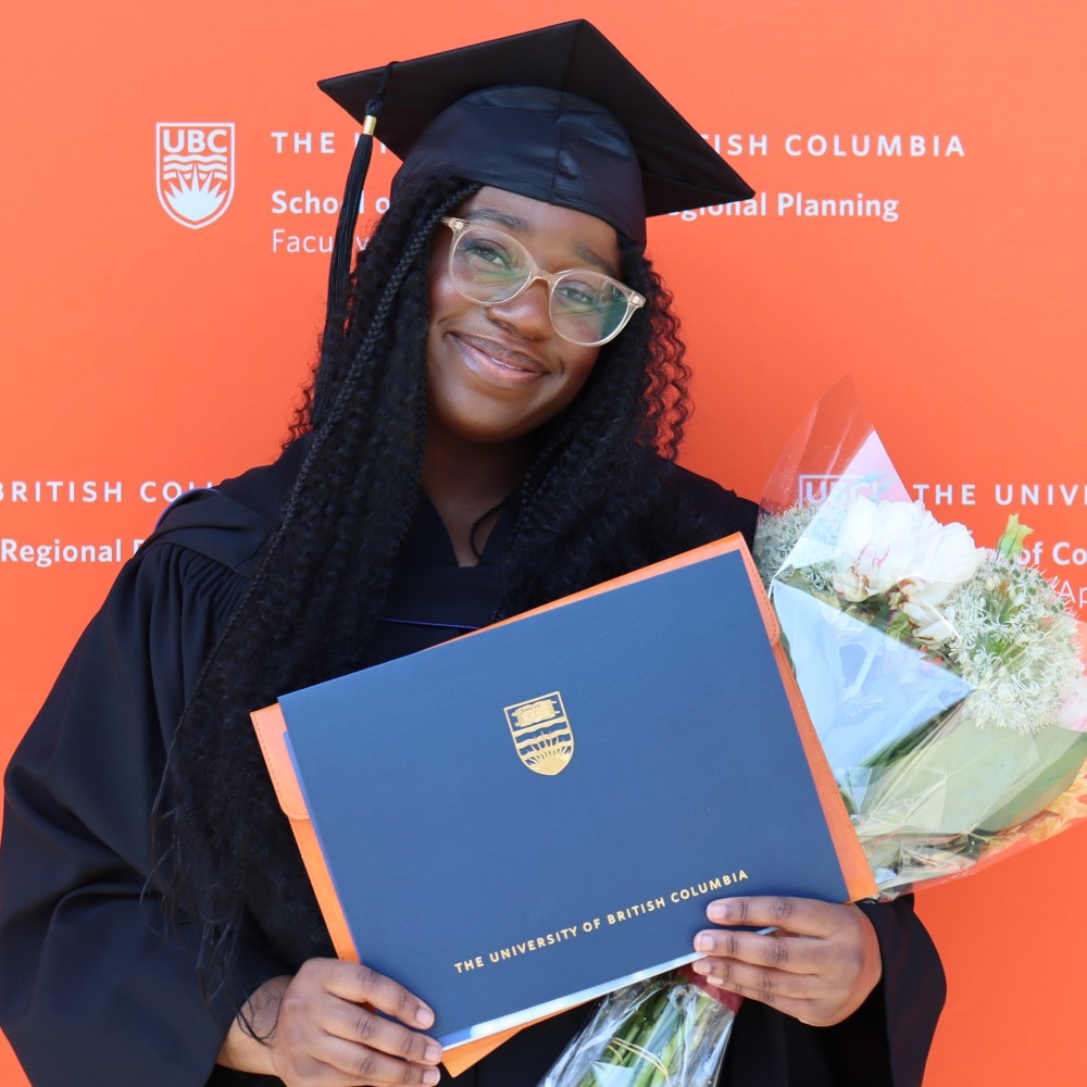 Woman in graduation regalia holding diploma in front of SCARP logo
