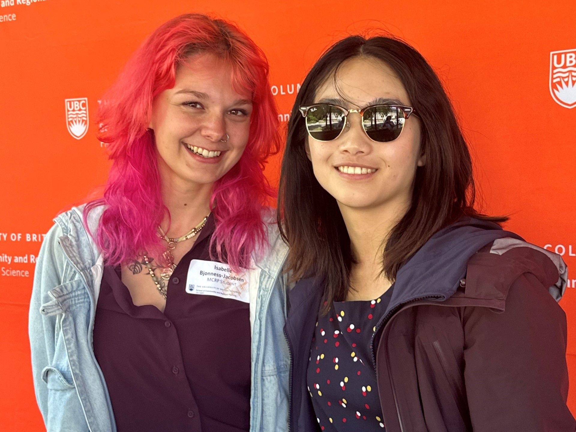 Two students in front of a SCARP logo