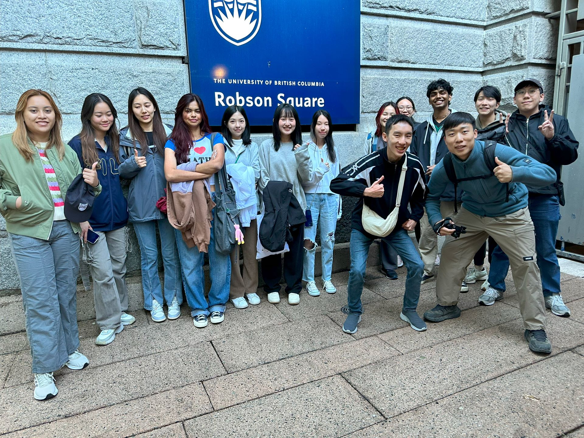 Students posing in front of Robson Square sign