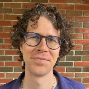 Person in front of brick wall