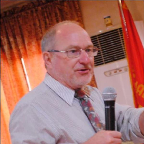Man talking into held microphone