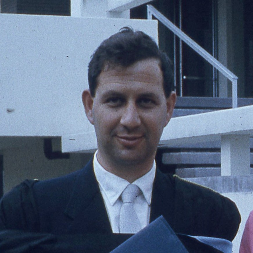 Old photograph of graduate in black suit and cyan tie