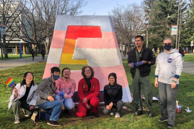 Students by monument, painted with both transgender and pride colours