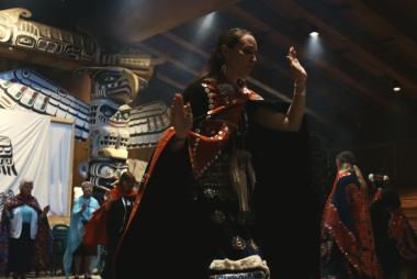 People dressed in Indigenous regalia on stage