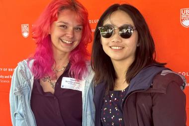 Two students pose in front of SCARP logo