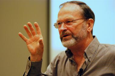 Man speaking in front of projector screen