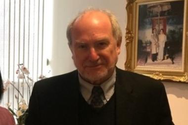Man in suit next to ornately framed art