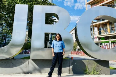 Student posing in front of giant UBC sign