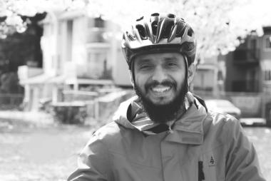 Dr. Adhikari, astride a bicycle