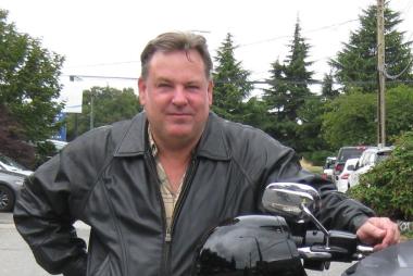 Dr. Douglas, leaning on a motorcycle