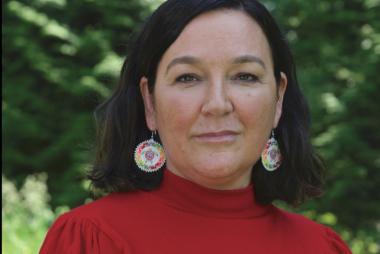 Woman in red turtle-neck, among trees