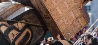 A part of Musqueam's Reconciliation pole at UBC, depicting hidden skeletons under a school