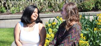 Madison and Meghna in UBC's Rose Garden, laughing with each other