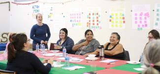 Students and Indigenous people laughing through a presentation