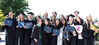 Grads in regalia posing in sunshine