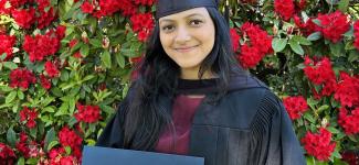 Woman in regalia holding diploma