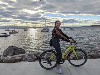 Holly, smiling on an e-bike my the coast
