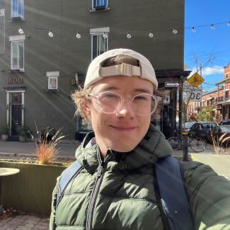 Student in backwards cap and overcoat, in Montreal neighbourhood