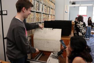 Student showing map-viewing machine to fellow student