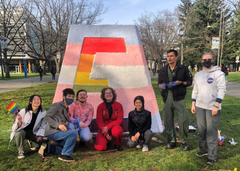 Students by monument, painted with both transgender and pride colours