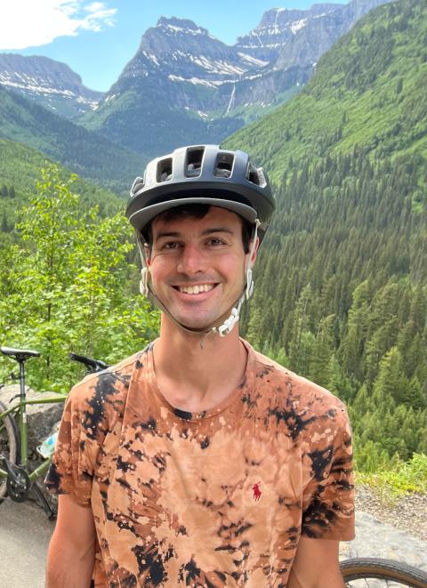 A man in a bicycle helmet among mountainpeaks