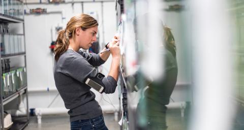 A woman writing on a whiteboard