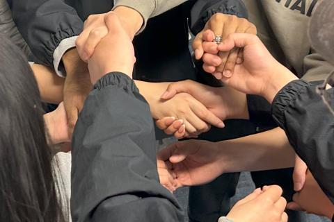 Several hands holding, in a collective knot