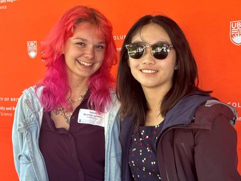 Two students pose in front of SCARP logo