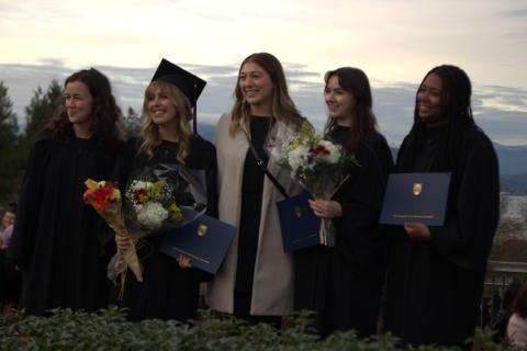 5 grads posing in the sunset