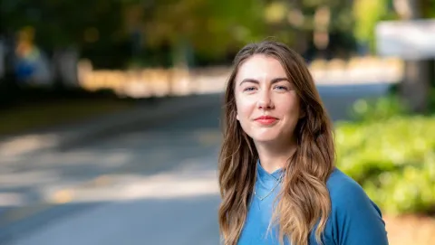 Woman in sunny grassy urban area