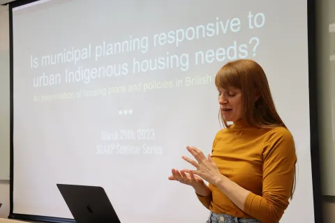 Woman lecturing in front of large screen