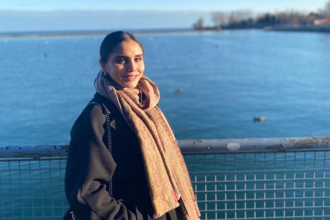 Woman in warm clothes by a bay