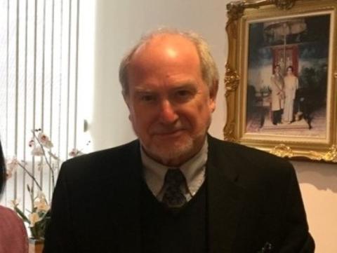 Man in suit next to ornately framed art
