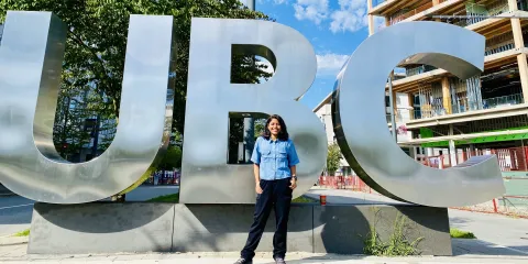 Student posing in front of giant UBC sign