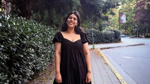 Woman in cobblestone street among heavy foliage