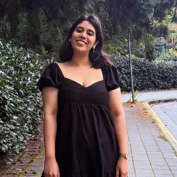 Woman on cobblestone sidewalk surrounded by foliage