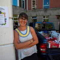 Zsuzsi Fodor, posing beside pickup truck of food