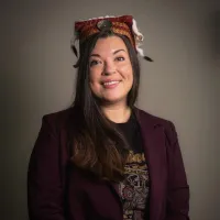 Woman in blazer wearing woven headdress