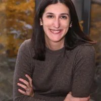 holly, sitting at bistro table smiling