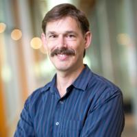 Man with moustache wearing striped blue button-up shirt
