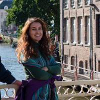 Ana Polgar leaning against a river bridge