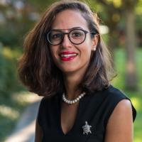 Meryem, smiling in a green setting