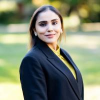 Woman in black blazer and mustard-coloured shirt