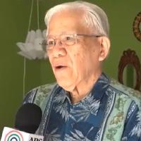 Elderly man speaking into mic