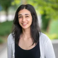 Woman in white shrug in park-like area
